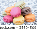 Colorful macaroons on a white lace background. 35604509