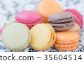Colorful macaroons on a white lace background. 35604514