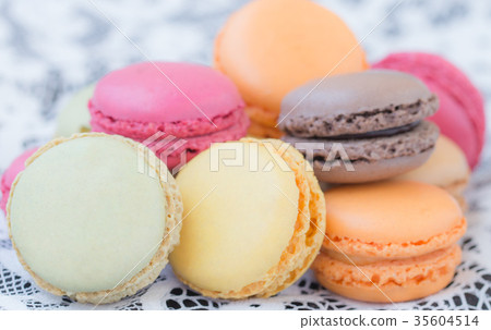 Colorful macaroons on a white lace background. 35604514