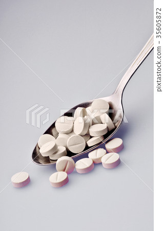 spoon with pills 35605872