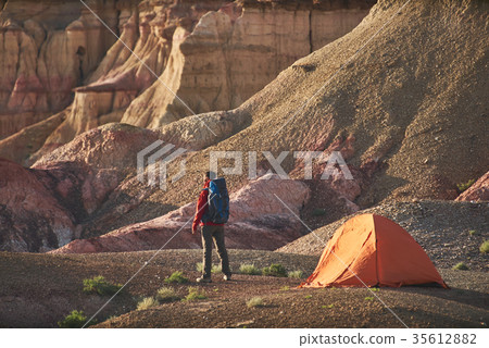 tourist stands near the tent and a canyon in 35612882