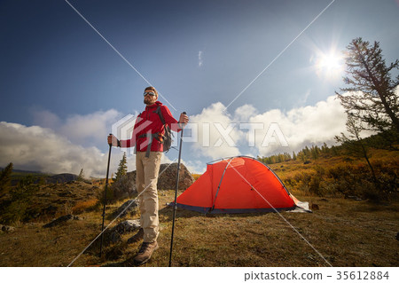 Backpacker with poles in hand. 35612884