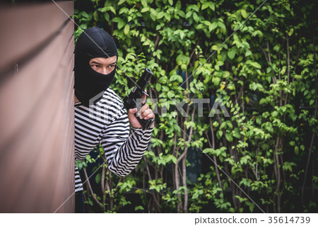 Robber hiding behind the wall 35614739
