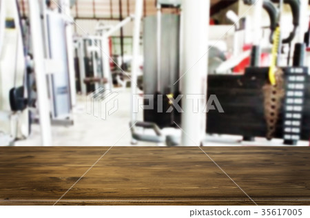 Wooden table on blurred background of fitness gym interior of mo 35617005
