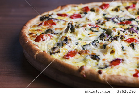 The fresh baked pizza with olives and tomatoes The fresh baked pizza with olives and tomatoes 35620286