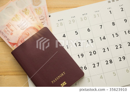 top view. money in passport and calender on desk top view. money in passport and calender on desk 35623910