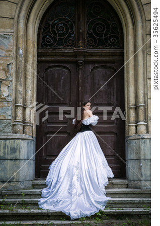 Woman in white Victorian dress with old door Woman in white Victorian dress with old door 35625494