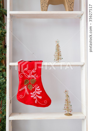 red christmas sock hanged above white stairs in 35627517