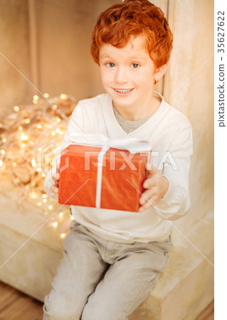 Excited ginger child showing his present Excited ginger child showing his present 35627622