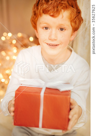 Adorable kid holding his precious christmas Adorable kid holding his precious christmas 35627625