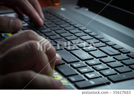 Men's hands are typing on the laptop's keyboard Men's hands are typing on the laptop's keyboard 35627683