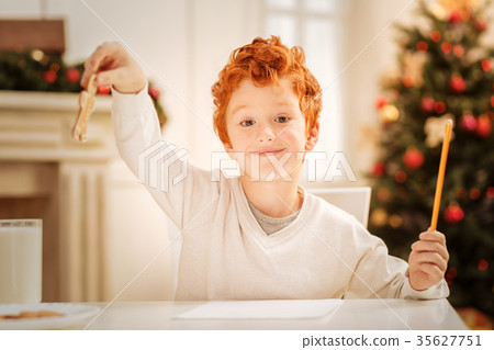 Charming redhead boy lifting gingerbread man and 35627751