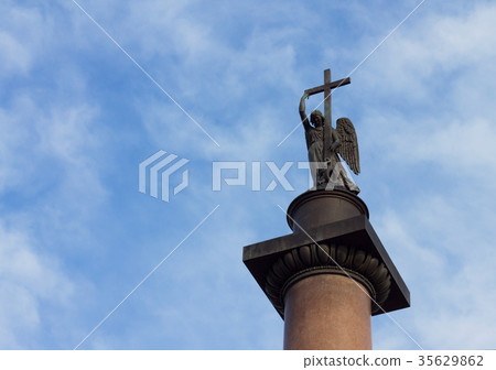 Angel with cross against cloudy blue sky 35629862