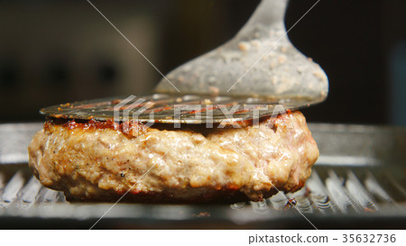Cook turns over a beefsteak on a grill Cook turns over a beefsteak on a grill 35632736
