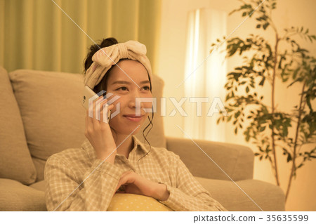 打電話的婦女在智能手機在上床前 打電話的婦女在智能手機在上床前 35635599