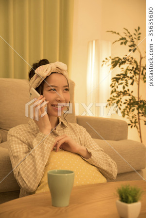 Woman making a call on smartphone before going to bed 35635600
