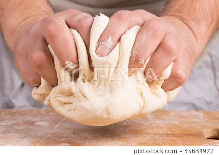 Baker holds raw dough in hands Baker holds raw dough in hands 35639972