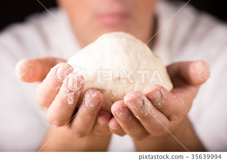 Baker holds raw dough in hands Baker holds raw dough in hands 35639994