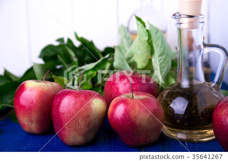Apple cider vinegar. One glass bottle on blue 35641267