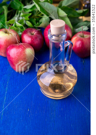 Apple cider vinegar. One glass bottle on blue 35641522