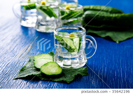 Cucumber water in little mason glass jar on blue Cucumber water in little mason glass jar on blue 35642196
