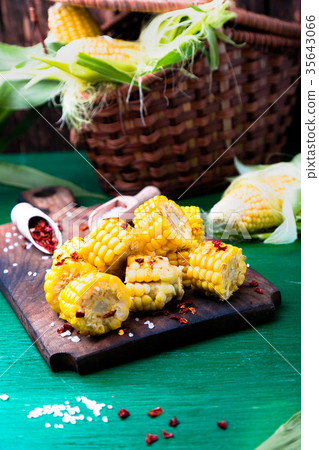 Grilled corn slices on wooden board with salt  35643066
