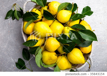 Yellow pear in grey basket in grey background Yellow pear in grey basket in grey background 35643154