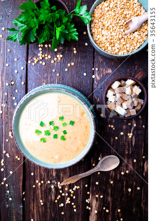 Pea soup in green bowl on brown wooden Pea soup in green bowl on brown wooden 35643155