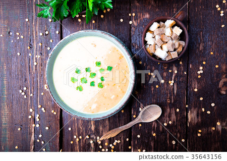 Pea soup in green bowl on brown wooden Pea soup in green bowl on brown wooden 35643156