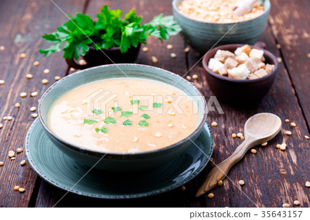Pea soup in green bowl on brown wooden 35643157