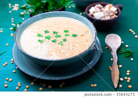 Pea soup in green bowl on green wooden 35643273