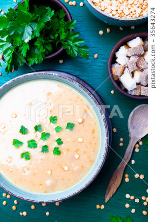Pea soup in green bowl on green wooden Pea soup in green bowl on green wooden 35643274