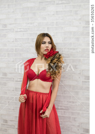 Woman in sexy red swimsuit poses in bedroom. Woman in sexy red swimsuit poses in bedroom. 35650265
