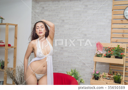 Woman in sexy dress white poses in bedroom. 35650389