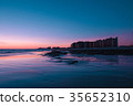 Sunset over a rocky beach in front the hotels 35652310