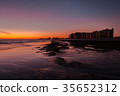 Sunset over a rocky beach in front the hotels 35652312