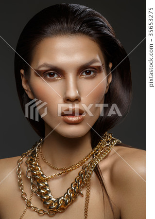 beautiful girl with many golden and bronze chains 35653275