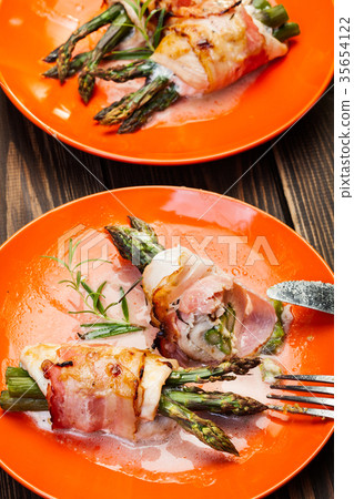 Baked fresh asparagus wrapped in chicken and bacon Baked fresh asparagus wrapped in chicken and bacon 35654122