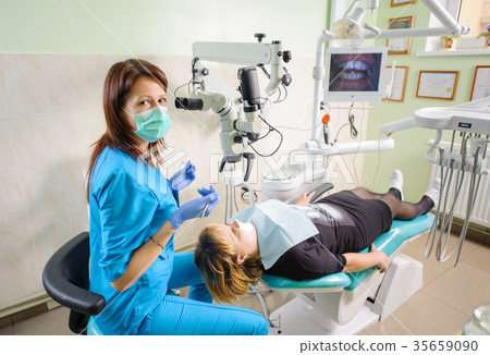 Female dentist working with microscope at modern dentist clinic Female dentist working with microscope at modern dentist clinic 35659090