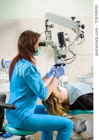 Female dentist working with microscope at modern dentist clinic Female dentist working with microscope at modern dentist clinic 35659091