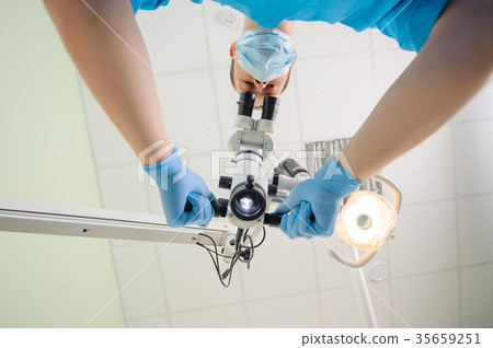 Doctor with a microscope in a dental clinic Doctor with a microscope in a dental clinic 35659251