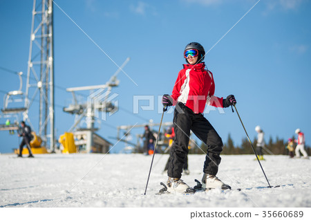 Woman skier with ski at winer resort in sunny day Woman skier with ski at winer resort in sunny day 35660689