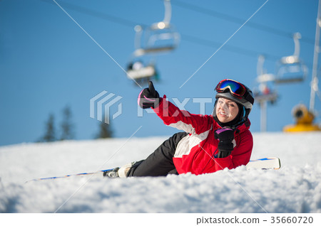 Woman skier with ski at winer resort in sunny day Woman skier with ski at winer resort in sunny day 35660720