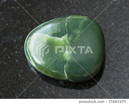 tumbled green nephrite gemstone on dark 35665970