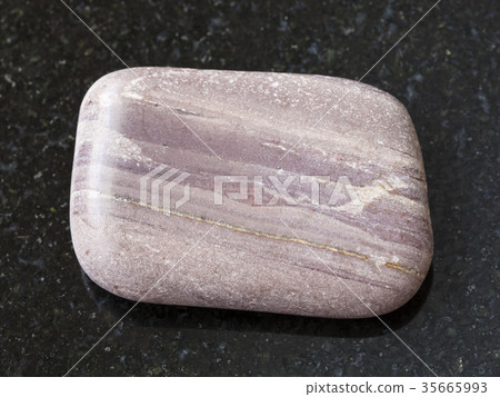 tumbled Argillite gemstone on dark background 35665993