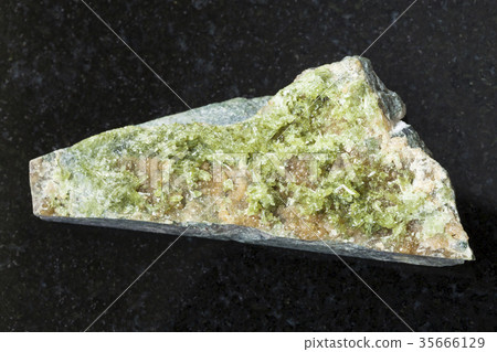 raw crystal of green Vesuvianite gemstone on dark 35666129
