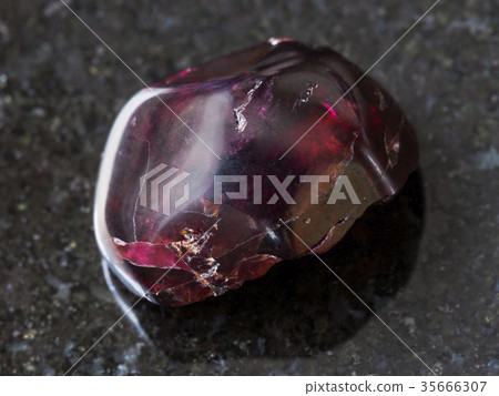 tumbled red garnet gemstone on dark background tumbled red garnet gemstone on dark background 35666307