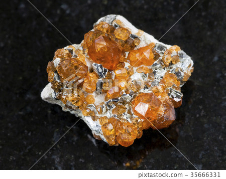 rough crystals of spessartine gemstone on dark 35666331