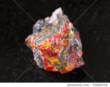 rough Realgar crystals on stone on dark 35666438