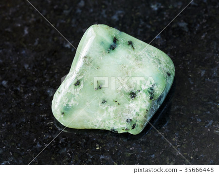 polished green Grossular gemstone on dark 35666448